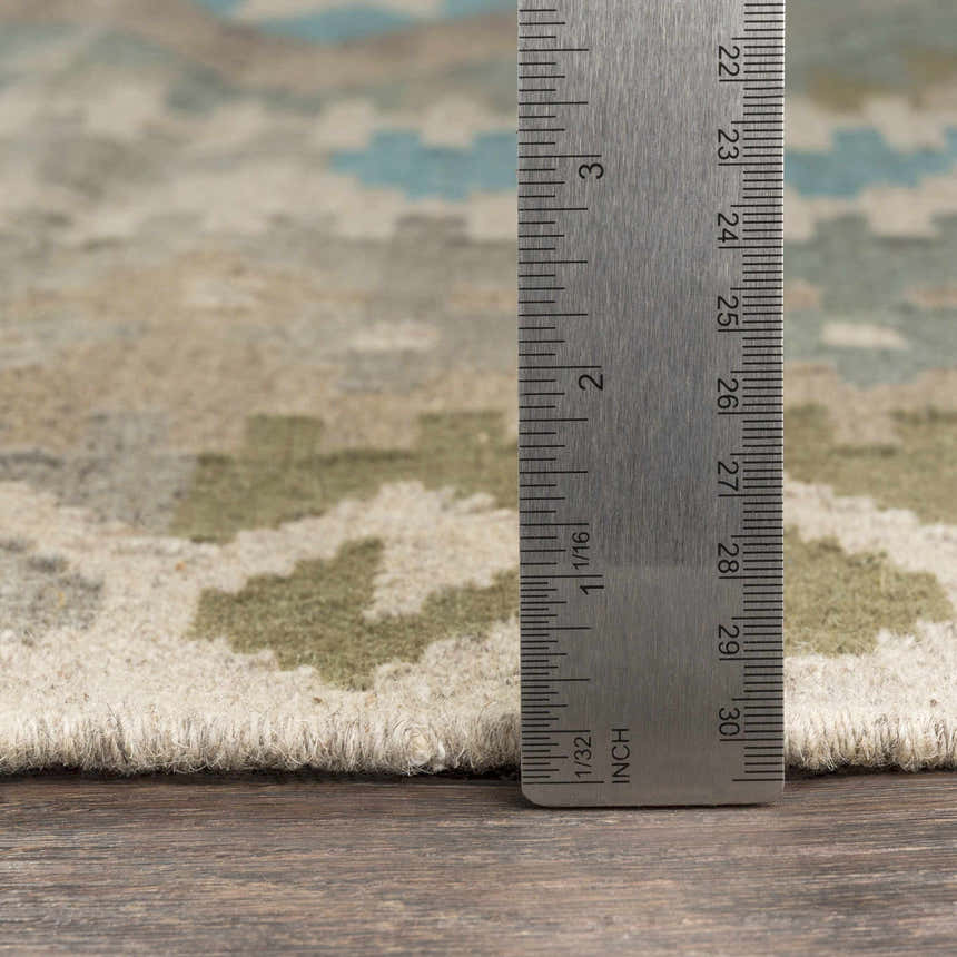 Close up of Auchterarder Carpet showing hand woven texture, aqua, sage, tan colors, and pile height with a ruler. Pile