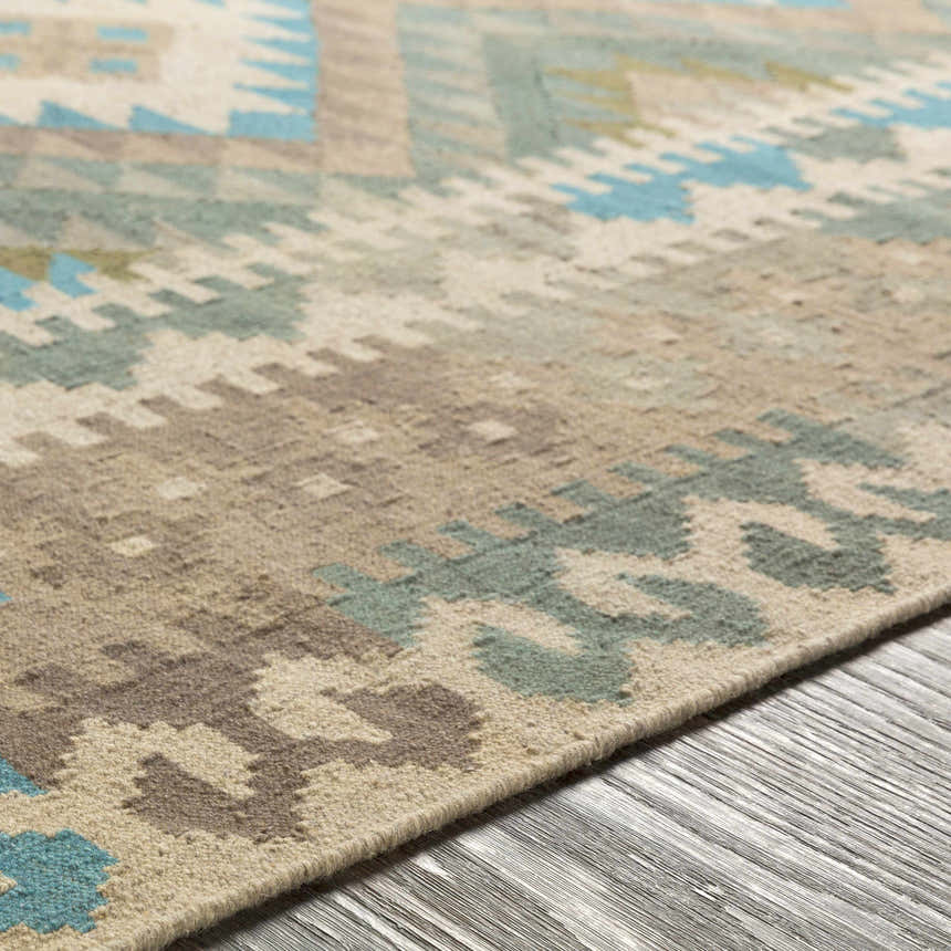 Close-up of Auchterarder Carpet, a hand-woven wool rug with a farmhouse design in aqua, sage, tan, and brown hues. Texture