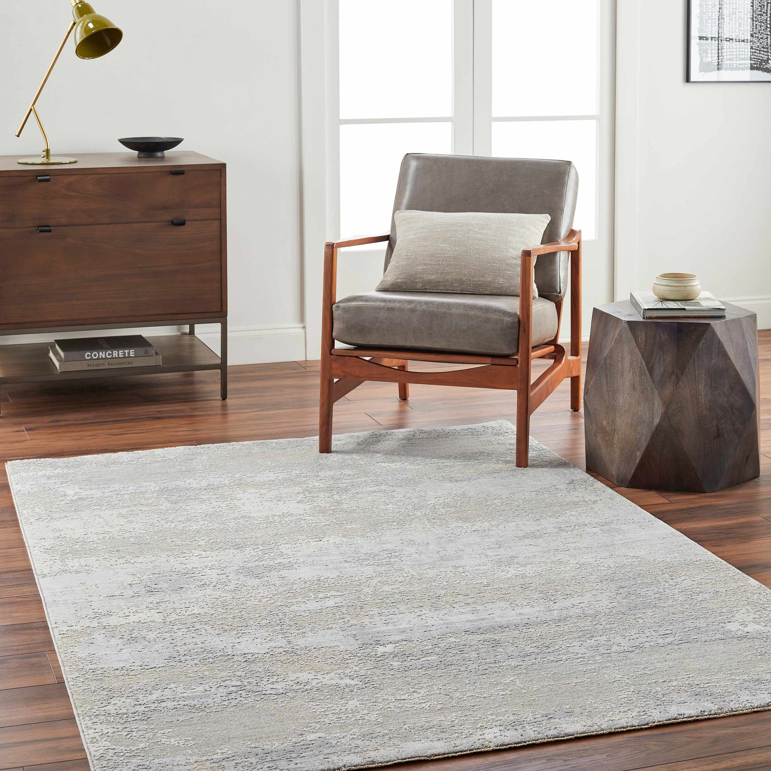 Living room scene with a gray Avani Thick Luxe Boutique Rug, gray chair, wood accents, and dark wood floors. Roomscene-Rectangle