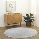 Entryway with light wood floors, cabinet, and round Avani Thick Luxe Boutique Rug in gray tones. Roomscene-Round