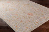 Close-up of the Awena Thick Luxe Area Rug, a traditional style rug with amber, brown, pink, and gray floral patterns. Corner