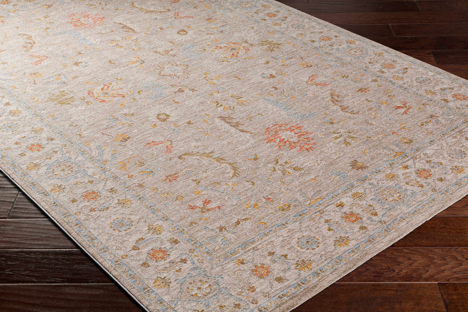Close-up of the Awena Thick Luxe Area Rug, a traditional style rug with amber, brown, pink, and gray floral patterns. Corner