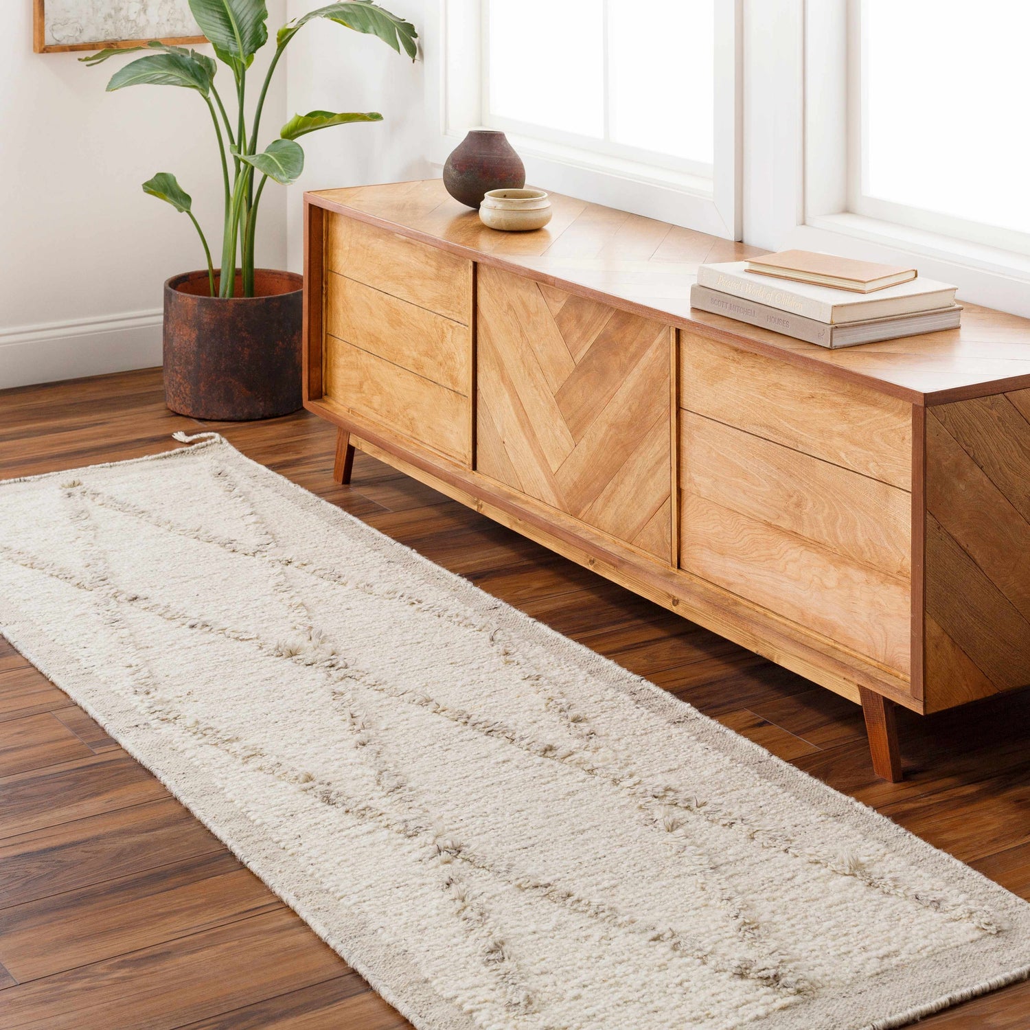Entryway scene with beige Awen Hand Knotted Wool Area Rug runner, wood console table, plant, and dark wood floors. Roomscene-Runner