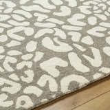 Close-up of the beige and gray Azuka Leopard Print Area Rug, a hand-tufted wool rug with a contemporary animal print design. Texture