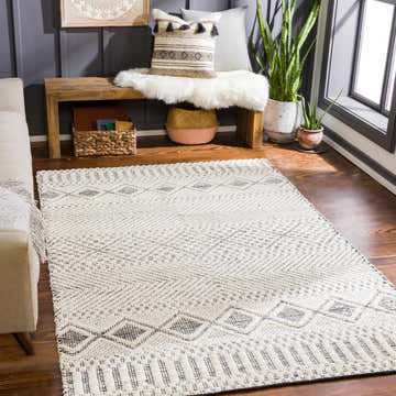 Living room scene with cream sofa and Bachauan Jute Carpet. Bohemian style with geometric black and cream pattern. Roomscene-Rectangle