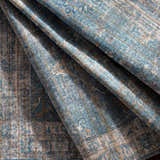 Close-up of the Bagontapay Washable Area Rug showing its blue, cream, and light brown traditional pattern and chenille texture. Fold