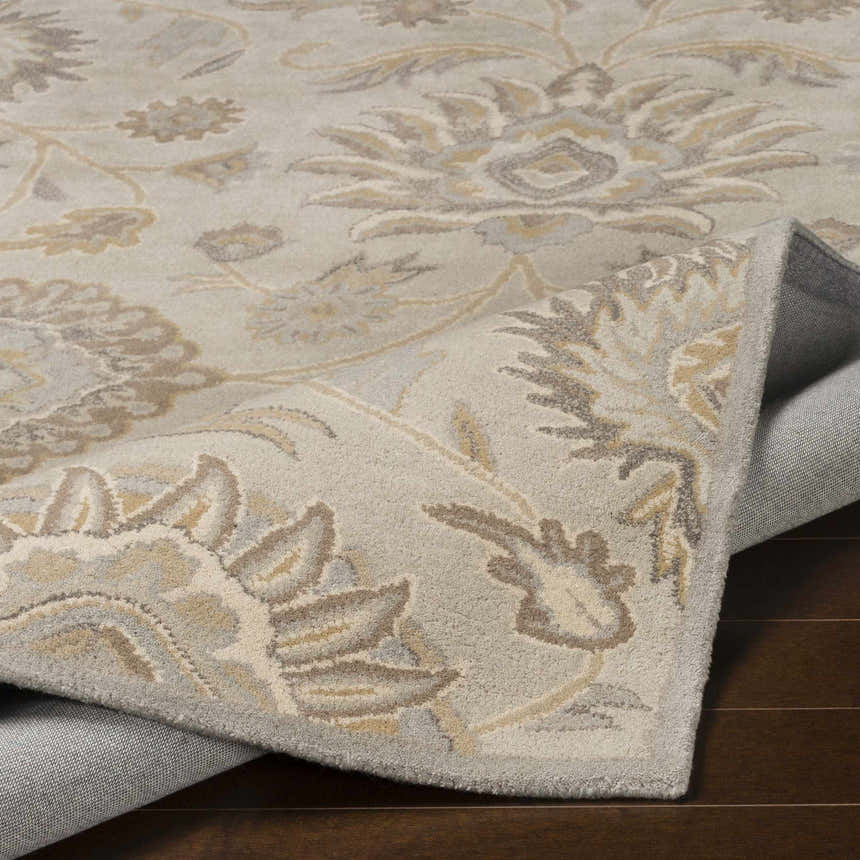 Close-up of the hand-tufted Conesus 1192 rug, featuring an ivory and taupe floral design on a soft, textured wool surface. Fold