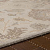 Close-up of the Conesus 1192 rug. Hand-tufted wool rug in ivory and taupe with a floral pattern on a hardwood floor. Texture