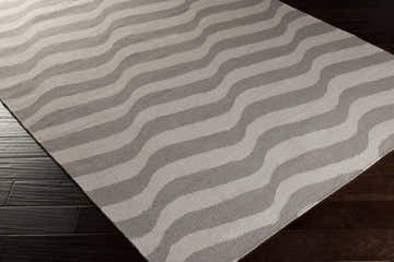 Close-up of the Balsam Area Rug. Light gray and slate wavy stripes on a hand-woven wool rug. Contemporary style. Corner