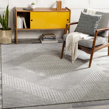 Living room scene with gray Banayoyo Area Rug, mid-century chair, yellow cabinet, and wood-look floors. Roomscene-Rectangle