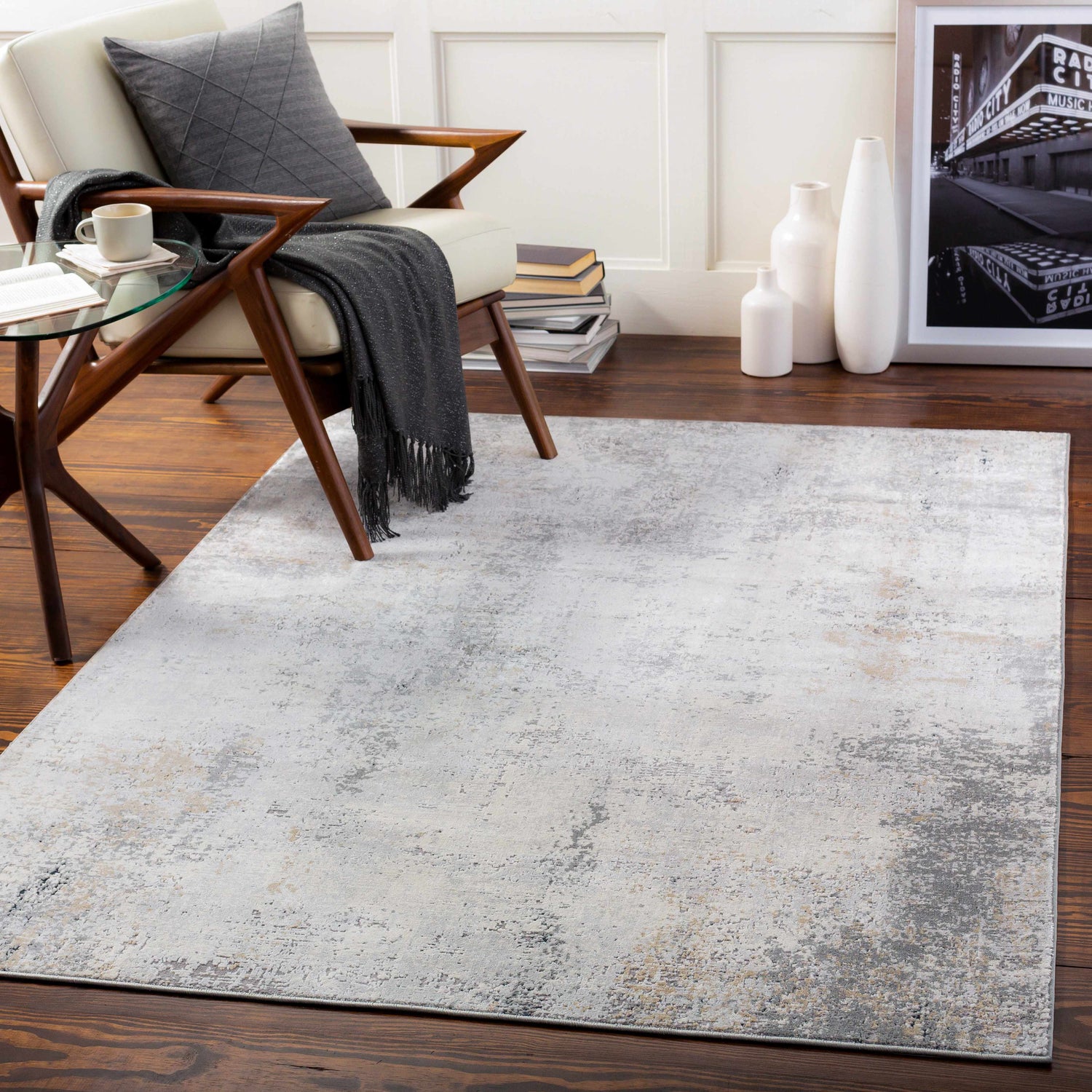 Living room scene with Baranduda Abstract Gray Luxe Rug, cream chair, wood floors, and modern decor. Roomscene-Rectangle
