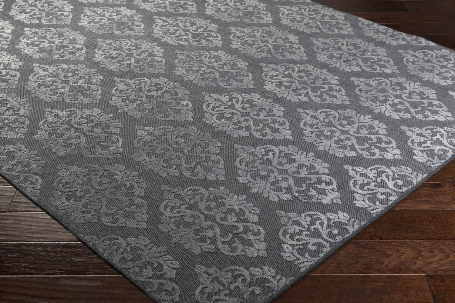 Close-up of the gray Barclay Carpet showing its contemporary floral damask pattern and hand-loomed texture. Corner