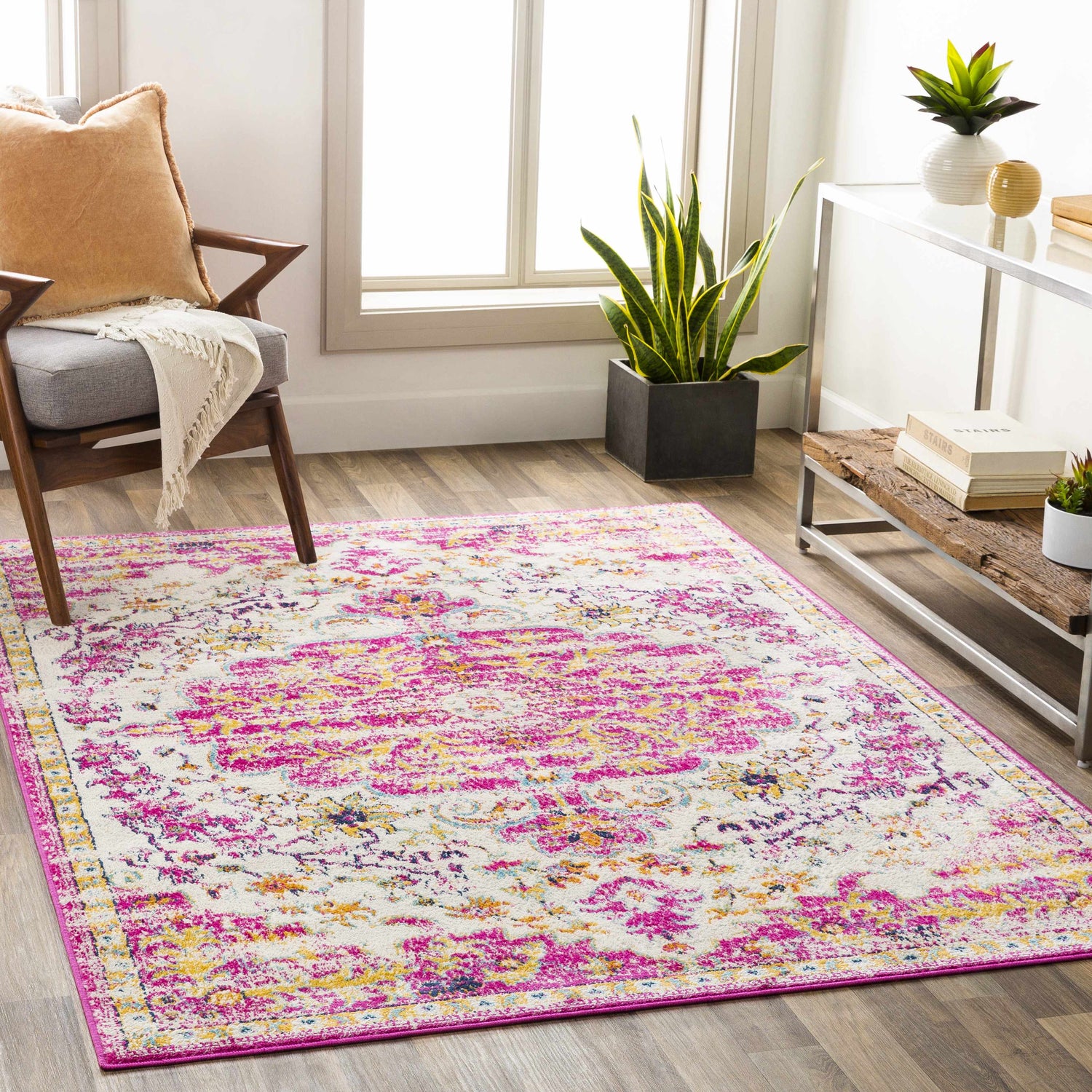 Living room scene with a Barceloneta Magenta Area Rug, wood floors, gray chair, and modern console table with plants. Roomscene-Rectangle