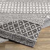 Close-up of the Barnwood Washable Area Rug showing its black and cream Bohemian pattern and machine woven texture. Fold