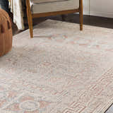 Living room scene with Terlingua Blush Greek Mosaic Carpet, tan chair, and brown pouf. Bohemian style rug. Roomscene-Rectangle