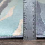 Close up of Basco Area Rug showing pile height with ruler. Aqua, beige, and charcoal colors. Pile
