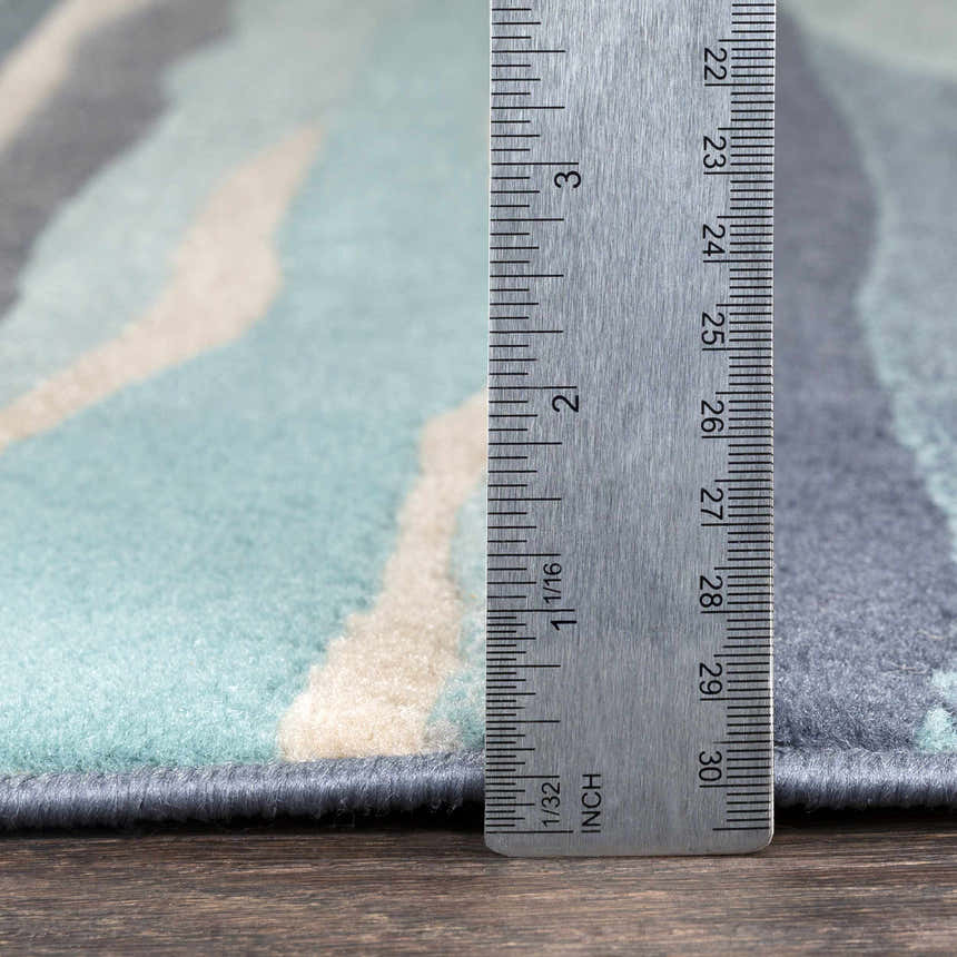 Close up of Basco Area Rug showing pile height with ruler. Aqua, beige, and charcoal colors. Pile