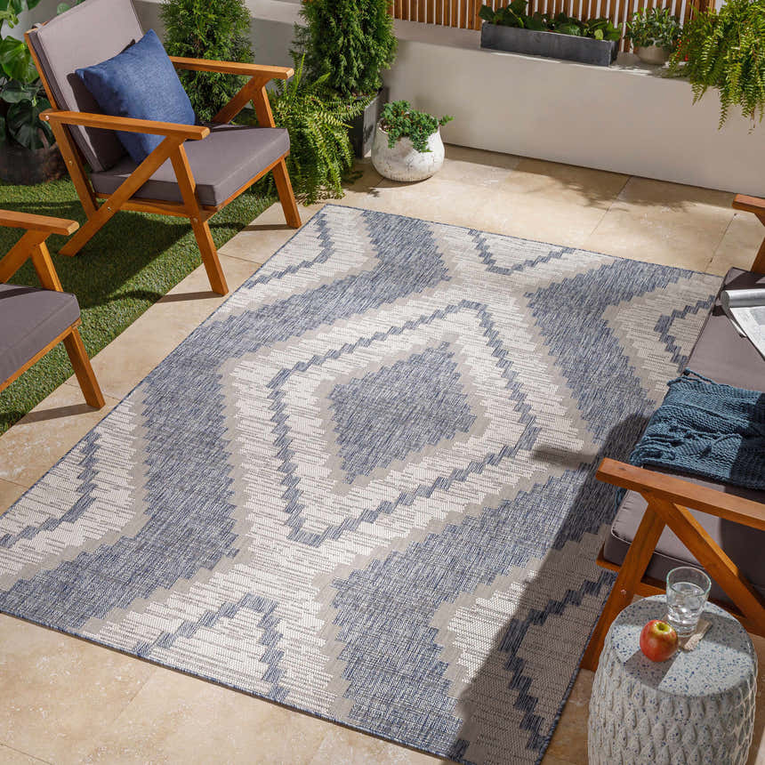 Outdoor patio scene with McCrory Pale Blue Flat Rug, wood chairs, plants, and side table. Roomscene-Rectangle