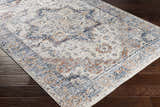 Close-up of the Bayog Area Rug, a machine-woven polyester rug with a traditional brick red, cream, and navy pattern. Corner