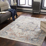 Living room scene with a brick red, cream, and denim Bayog Area Rug, gray sofa, and dark wood floors. Roomscene-Rectangle