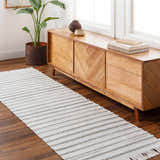 Entryway scene with a light gray Benek Area Rug runner, wooden cabinet, plant, and books. Roomscene-Runner