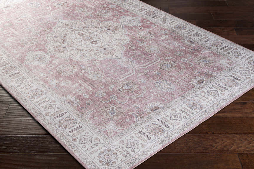Close-up of Bergman Distressed Red Area Rug showing blush, cream, and brown oriental pattern on dark wood floor. Corner