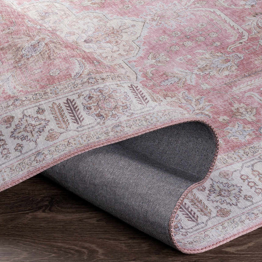 Close-up of Bergman Distressed Red Area Rug showing blush, cream, and red oriental pattern and gray backing. Fold