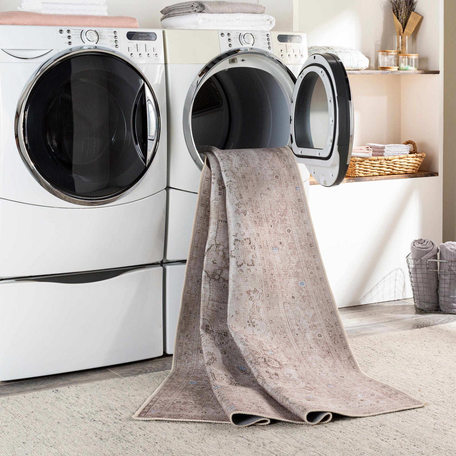 The Bethany Vintage Flat Pile Washable Rug in a laundry room, being taken out of the washing machine. Beige and blush tones. Washing-Machine