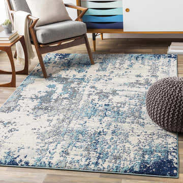 Living room scene with a Beverly Abstract Blue Area Rug, gray chair, and blue accent cabinet. Roomscene-Rectangle