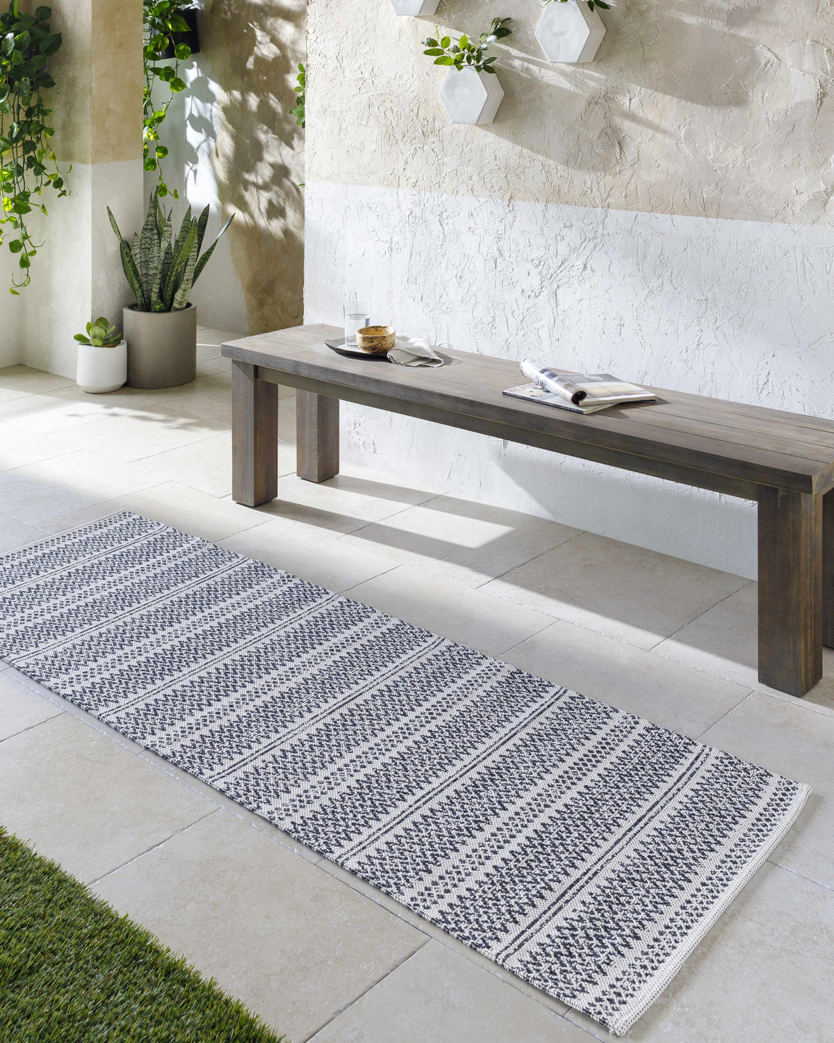Entryway with a Bewbush Washable Area Rug runner in black and cream. Bench with plants and textured wall. Roomscene-Runner