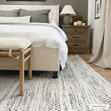 Bedroom scene with a black and cream Williford Wool Area Rug, white bed, wooden bench and nightstand. Roomscene-Rectangle