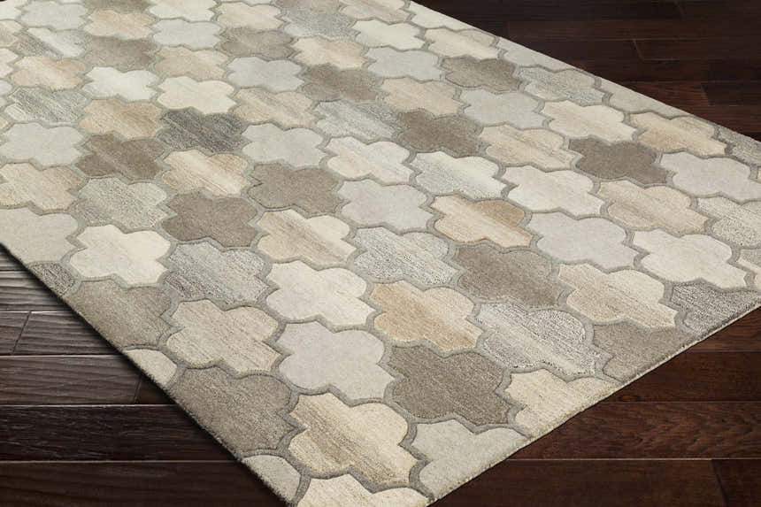 Close-up of the Bluffdale area rug, a hand-tufted wool rug with a quatrefoil pattern in beige, tan, and gray tones. Corner