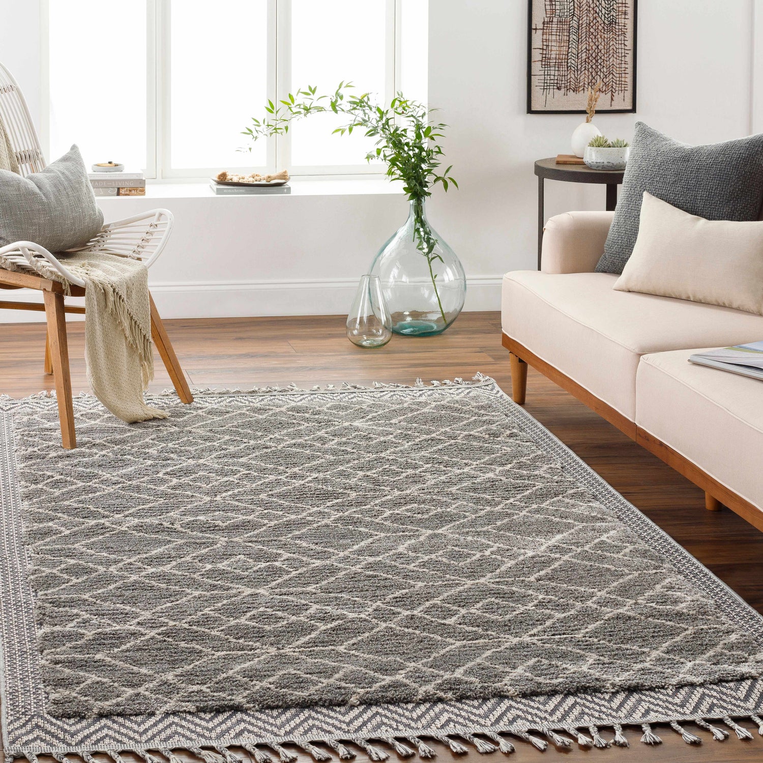 Living room scene with a gray and light beige Ballybunnion Area Rug, sofa, chair, and wood floors. Bohemian style. Roomscene-Rectangle