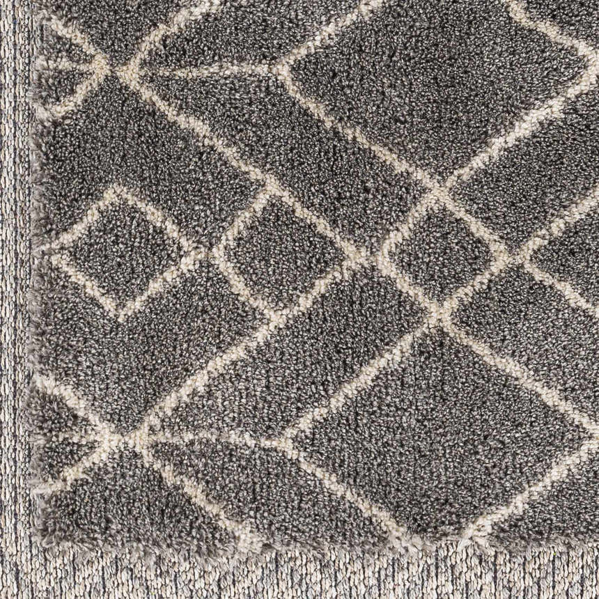 Close-up of the charcoal Ballybunnion Area Rug. Features a light beige geometric diamond pattern and soft, textured pile. Swatch