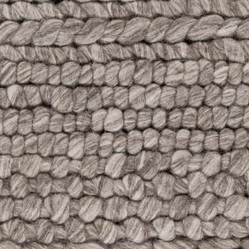 Close-up of the hand-woven Ballymena Area Rug. Features a chunky, textured wool design in brown, charcoal, and ivory tones. Swatch