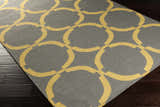 Close-up of the Bloomer Area Rug featuring a gray background and mustard yellow geometric circle pattern. Corner