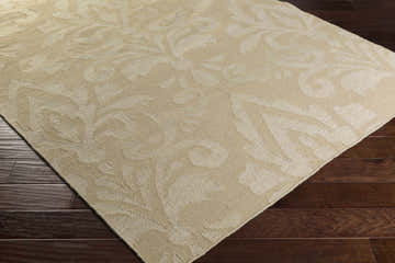 Close-up of the beige Bond Area Carpet showing its subtle floral pattern and texture on dark wood flooring. Corner