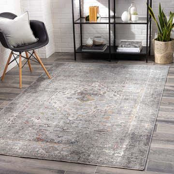 Modern room scene with a gray Boli Distressed Statement Rug, black chair, and black shelving unit against a white brick wall. Roomscene-Rectangle