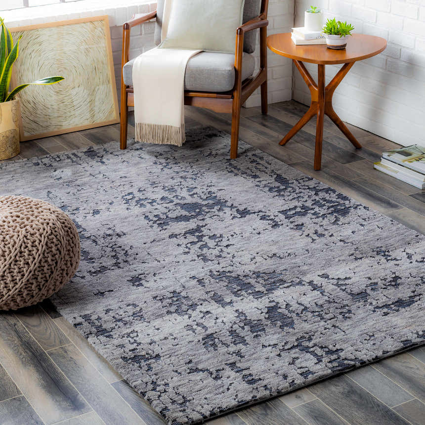 Living room scene with charcoal and gray Bomaderry Area Carpet, chair, and pouf. Contemporary style. Roomscene-Rectangle
