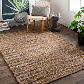Living room scene with jute Bombon Area Rug in beige and blue, woven stripes, chair, and plants. Roomscene-Rectangle