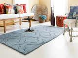 Living room scene with denim Bountiful Area Rug, white sofa, colorful pillows, and eclectic decor. Roomscene-Rectangle