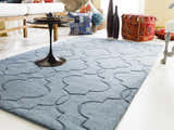 Living room scene with a denim Bountiful Area Rug, white sofa, and colorful pillows and poufs. Roomscene-Rectangle