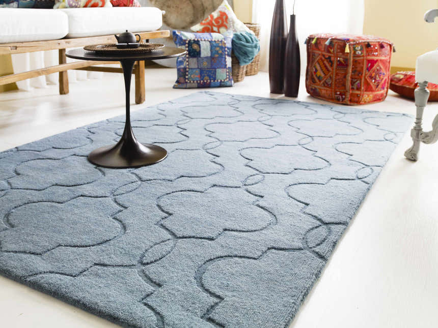 Living room scene with a denim Bountiful Area Rug, white sofa, and colorful pillows and poufs. Roomscene-Rectangle