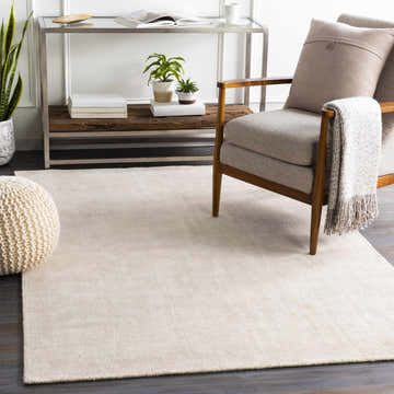 Living room scene with a cream Bowstring Carpet, gray armchair, and a modern console table. Roomscene-Rectangle
