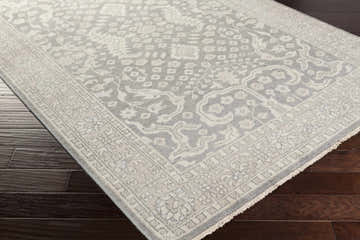 Close-up of the Bradfordsville Premium Rug, a wool rug in charcoal, sage, and taupe with a traditional floral pattern. Corner