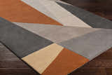 Close-up of the Bracknell Modern Wool Rug. Features a geometric design in brick red, charcoal, gray, tan, and taupe. Corner