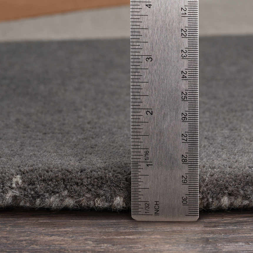 Close-up of the charcoal Bracknell Modern Wool Rug showing the pile height with a ruler. Pile