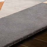 Close-up of the hand-tufted Bracknell Modern Wool Rug, showing its gray, tan, and brick red geometric design and wool texture. Texture