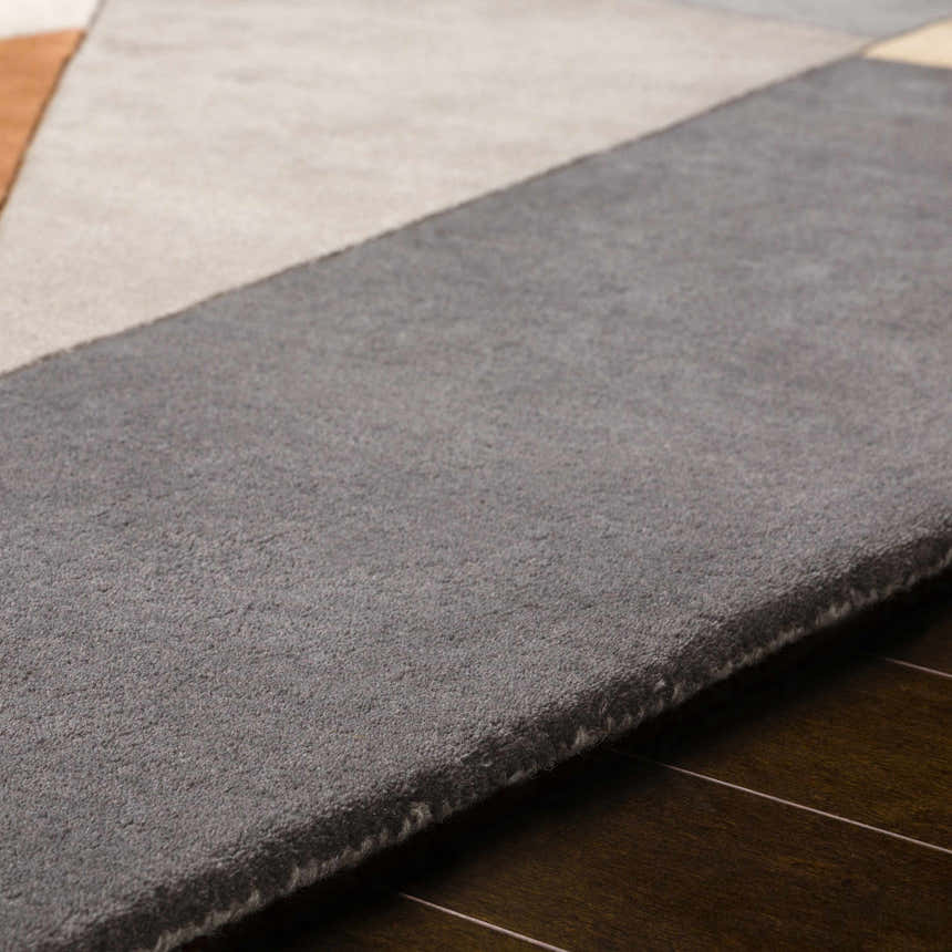 Close-up of the hand-tufted Bracknell Modern Wool Rug, showing its gray, tan, and brick red geometric design and wool texture. Texture