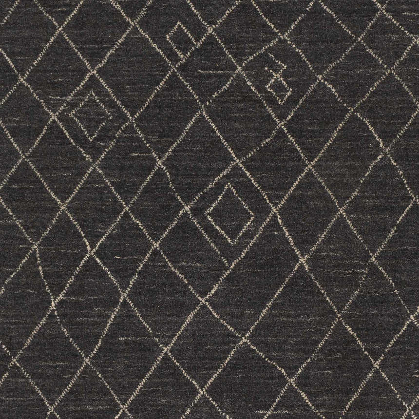 Close-up of Brimbank Premium Rug. Black wool rug with ivory diamond trellis pattern. Hand-loomed texture. Swatch